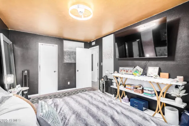 a bedroom with a large bed and a large mirror