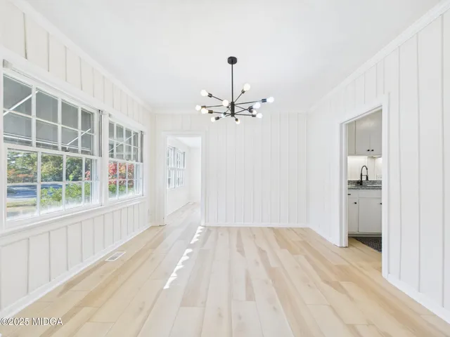 a view of a hallway with wooden floor and closet