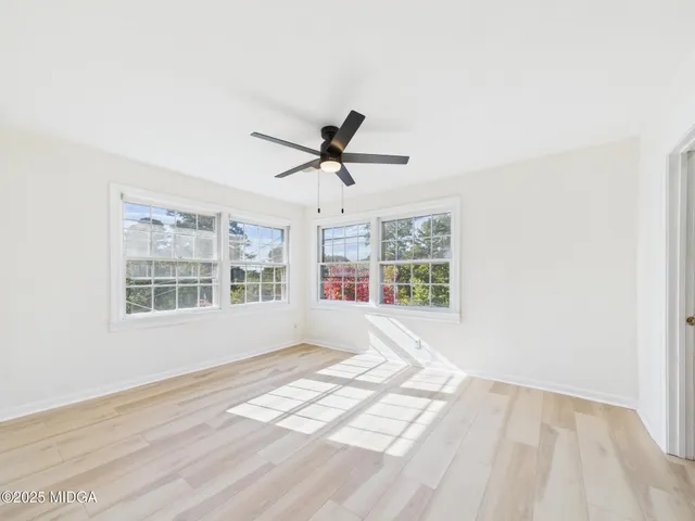 an empty room with closet and a ceiling fan