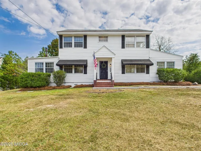 a front view of a house with yard and garage