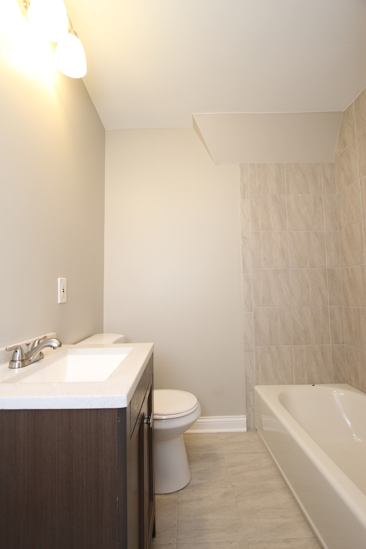 910 North Spring Street Elgin, IL 60120 - Photo 25 of 34 a bathroom with a sink a toilet and bathtub