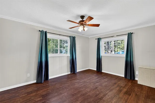a view of room with wooden floor and ceiling fan