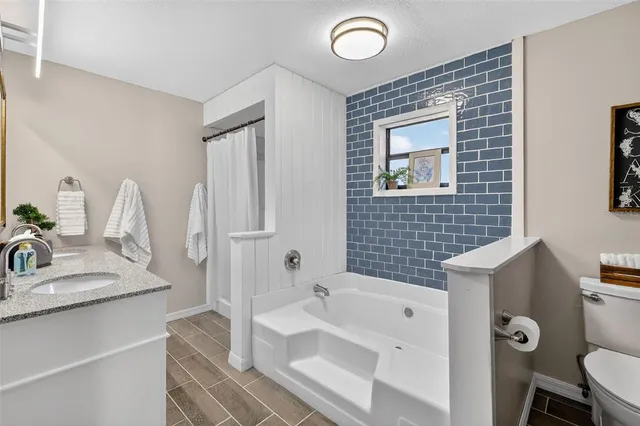 a bathroom with a tub sink and mirror