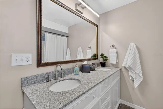 a bathroom with a granite countertop sink and a mirror