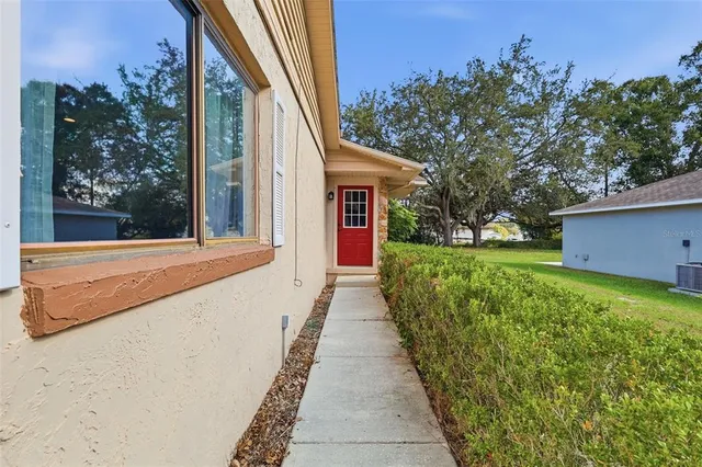 a backyard of a house with plants and wooden fence