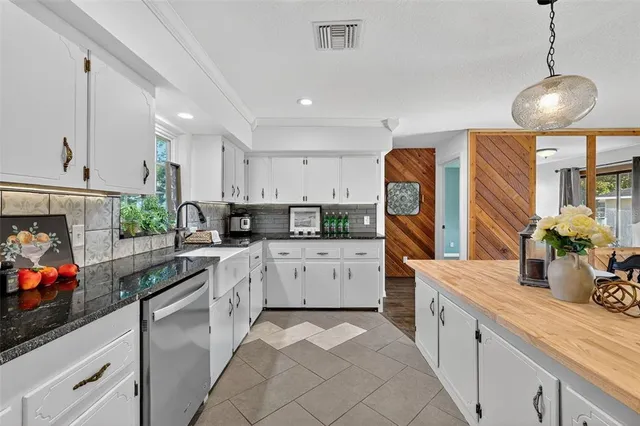 a kitchen with granite countertop a sink stainless steel appliances and cabinets