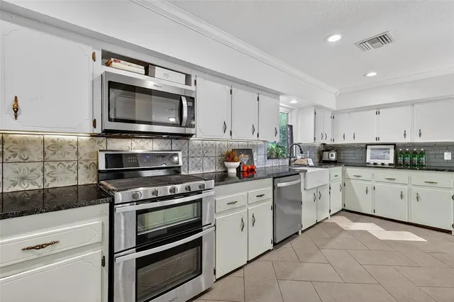 a kitchen with cabinets stainless steel appliances and a window