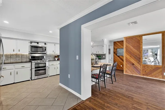 a kitchen with granite countertop stainless steel appliances and wooden floor