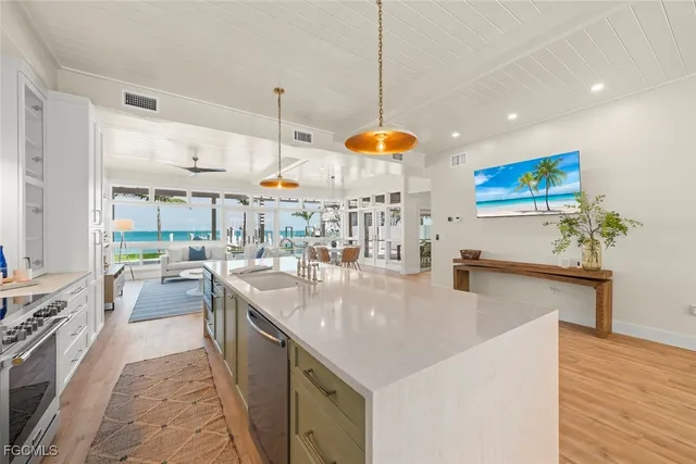 a kitchen with stainless steel appliances granite countertop a sink a stove and a wooden floors