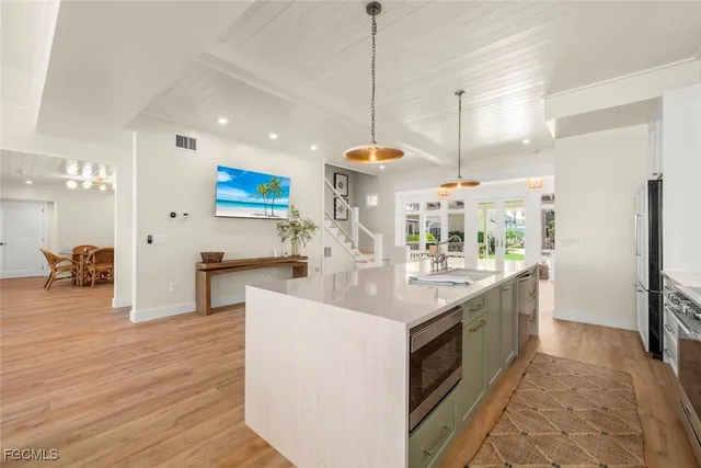 a kitchen with stainless steel appliances granite countertop a sink a stove and a wooden floors