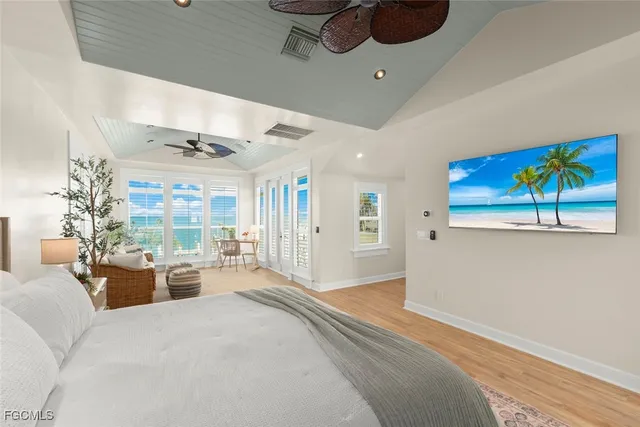 a bedroom with furniture large window and wooden floor