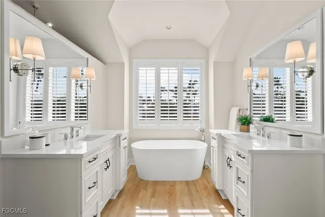 a spacious bathroom with a double vanity sink a large mirror and a bathtub
