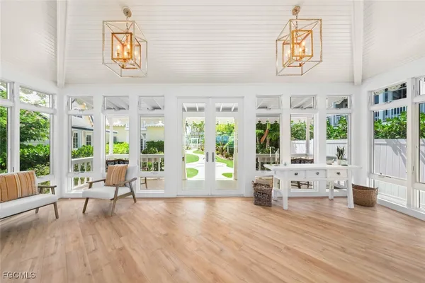 a living room with furniture floor to ceiling window and wooden floor