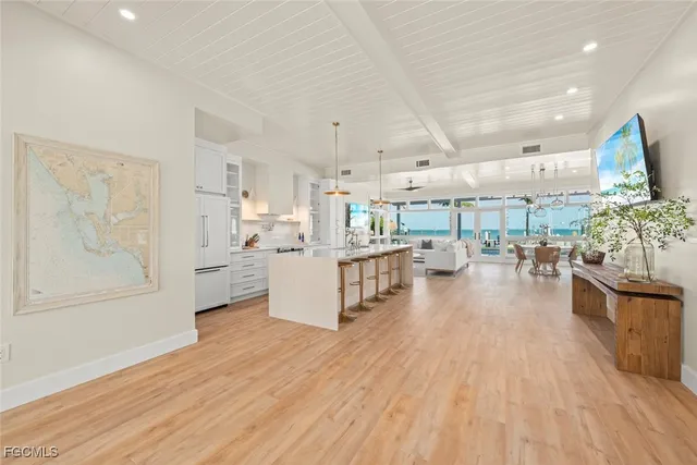 a living room with stainless steel appliances kitchen island wooden floors and living room view