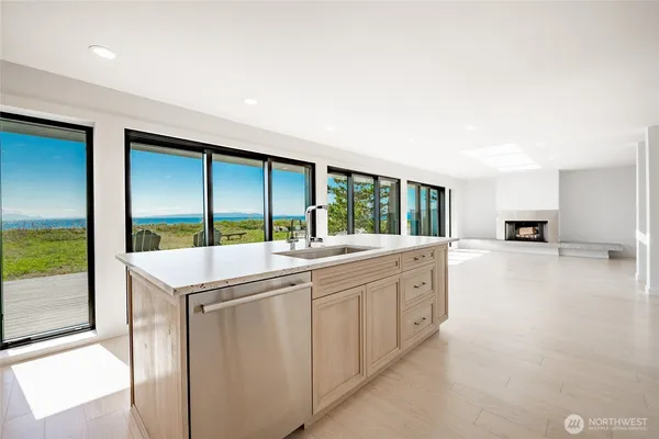a kitchen with kitchen island a stove a refrigerator and a dining table with wooden floor