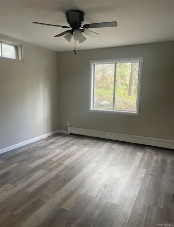 en empty room with windows and ceiling fan