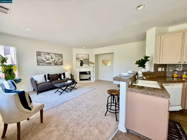 a living room with furniture and a dining table with potted plant