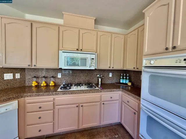 a kitchen with white cabinets and white appliances