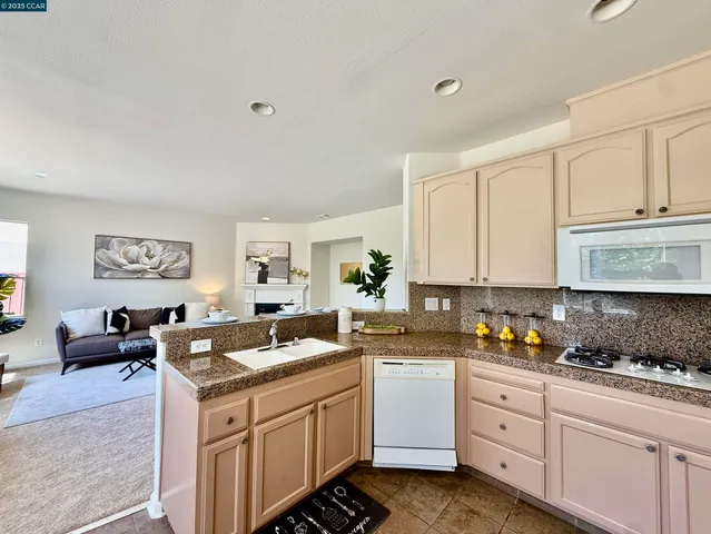 a kitchen with granite countertop a sink stove and cabinets