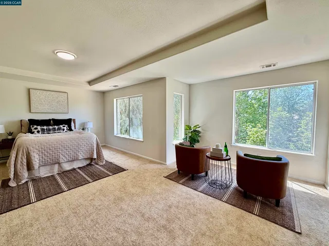 a bedroom with a large bed and windows