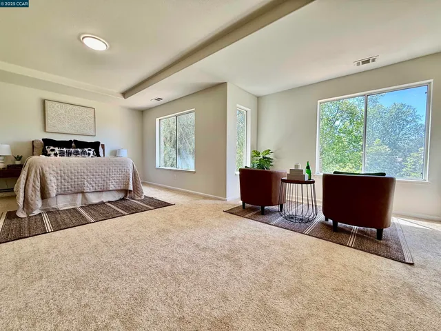 a bedroom with a bed and a painting on the wall