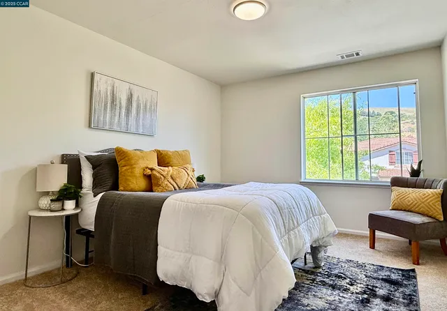 a bedroom with a bed and a painting on the wall