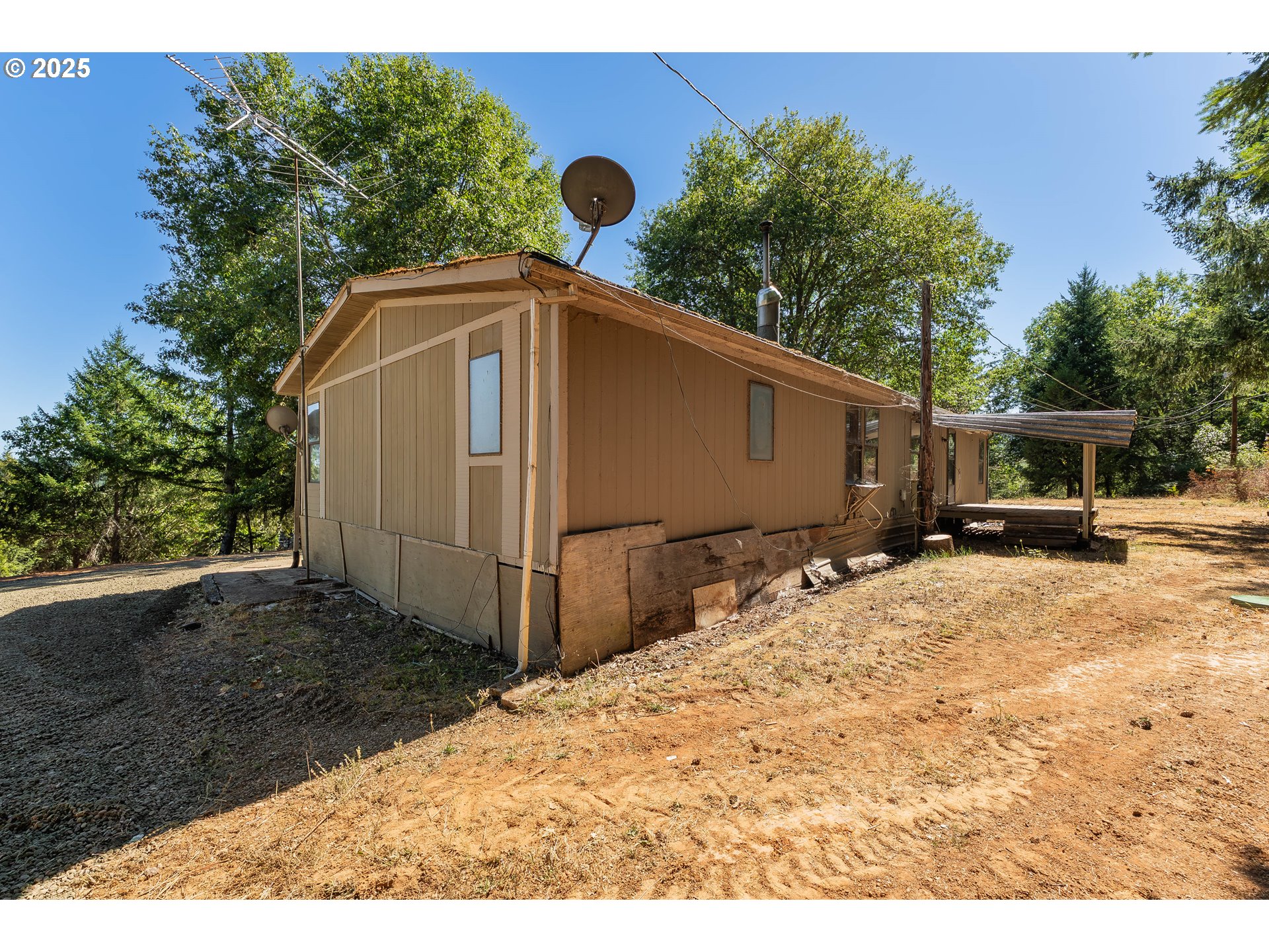 281 Callahan Road Roseburg, OR 97471 - Photo 11 of 39 a backyard of a house with wooden fence and large trees