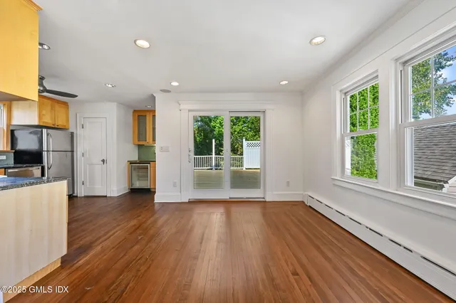 a view of a big room with wooden floor and windows