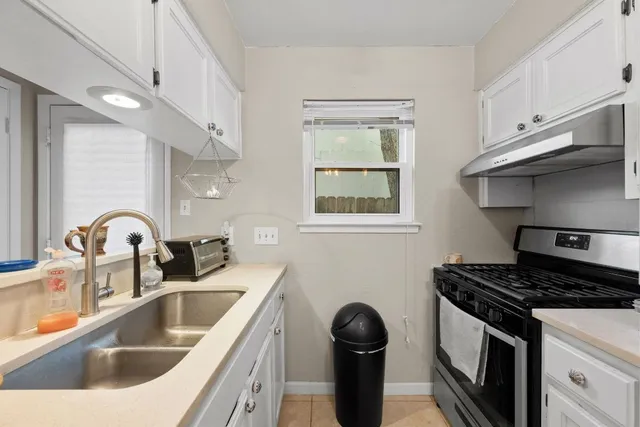 a kitchen with stainless steel appliances granite countertop a sink a stove and a refrigerator