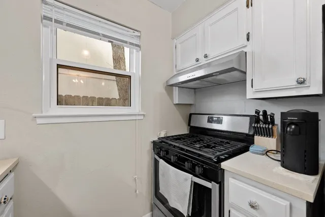 a kitchen with wooden cabinets and stove top oven