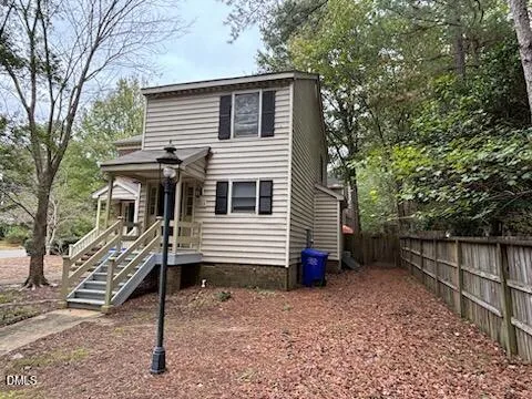 a view of a house with a yard and wooden fence