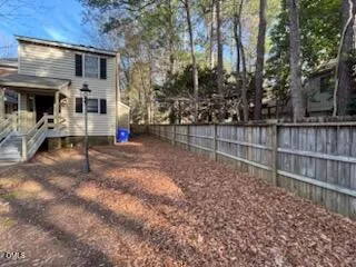 a view of a house with a small yard and wooden fence
