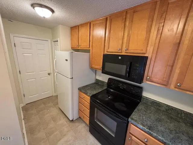 a kitchen with a refrigerator stove and cabinets