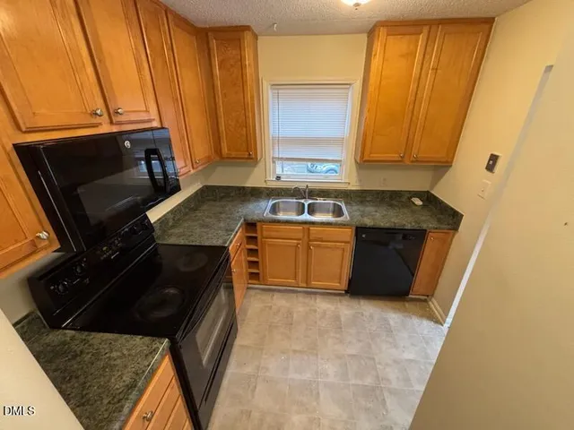 a kitchen with a sink a stove and cabinets