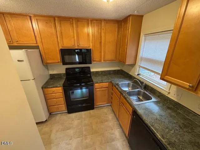 a kitchen with a stove a sink and a refrigerator