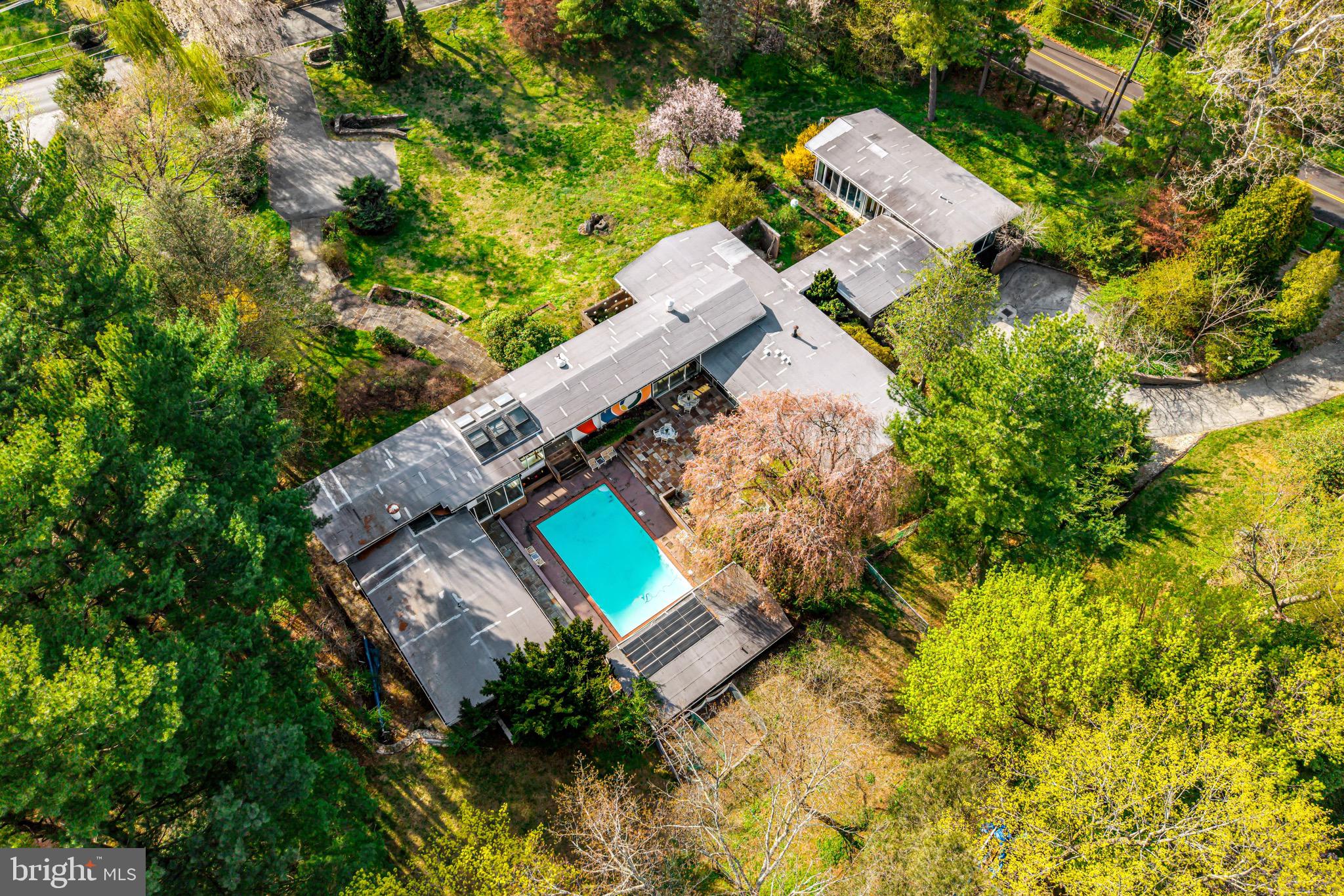 an aerial view of a house with a garden and trees