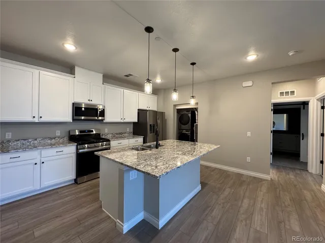 a kitchen with stainless steel appliances granite countertop a sink stove and refrigerator