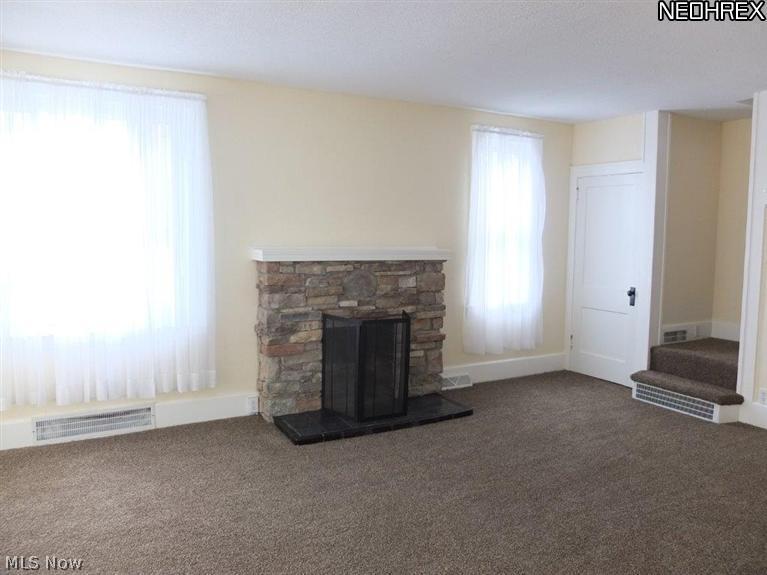 Living room with fireplace and new carpet.