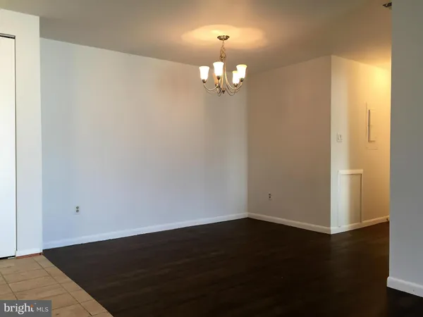 an empty room with wooden floor and cabinet