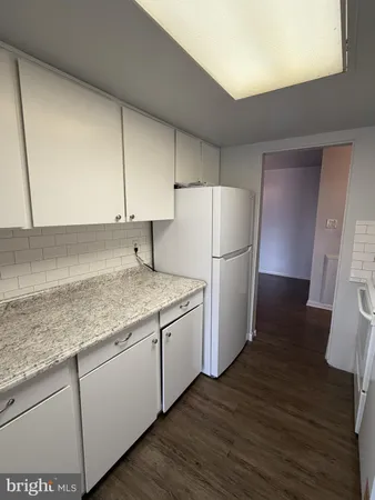 a kitchen with a sink a refrigerator a microwave and cabinets