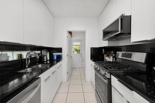 a kitchen with stainless steel appliances granite countertop a stove and cabinets
