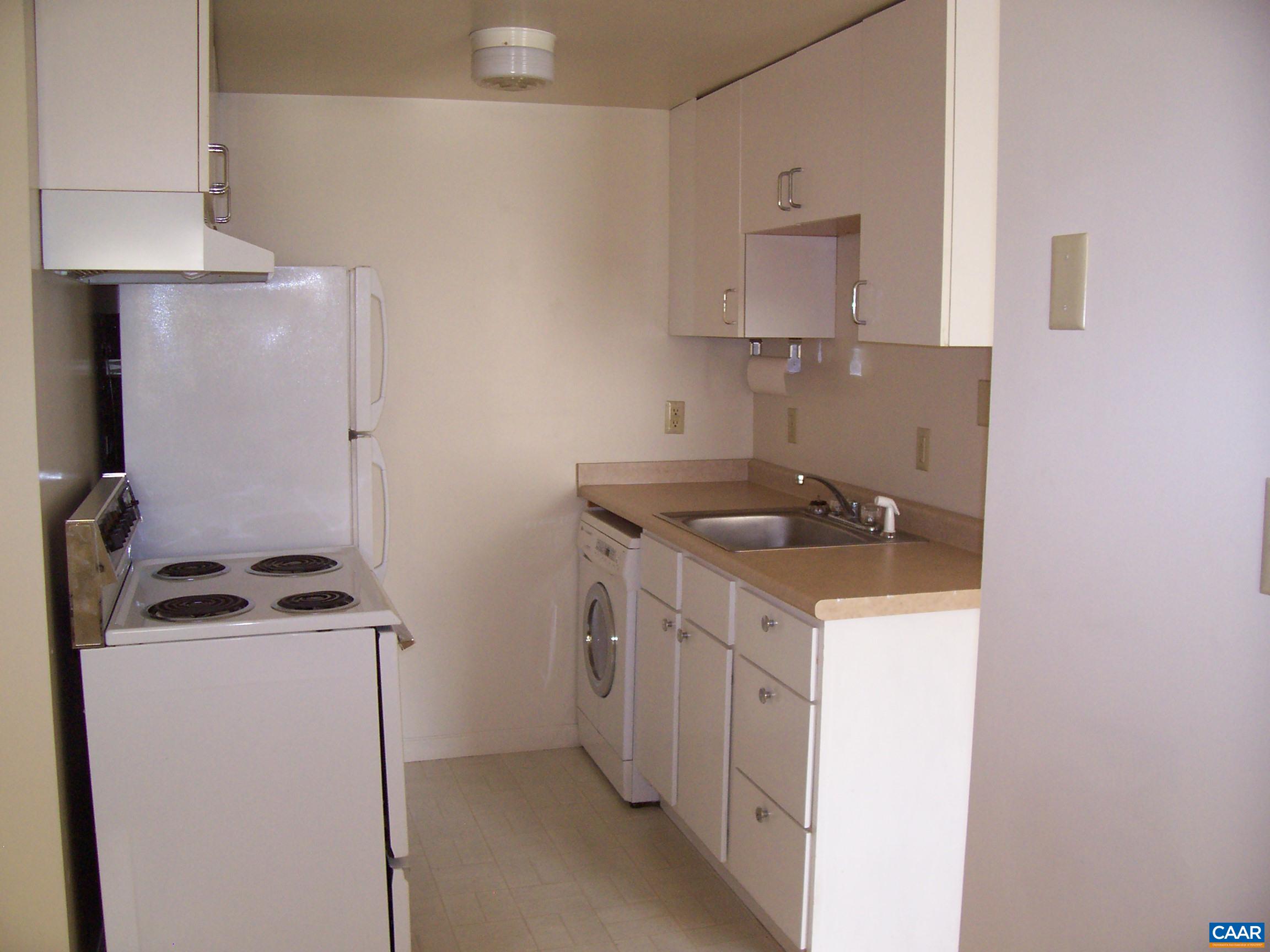 211 Chancellor Street, Unit A Charlottesville, VA 22903 - Photo 6 of 8 a kitchen with a sink a stove and cabinets