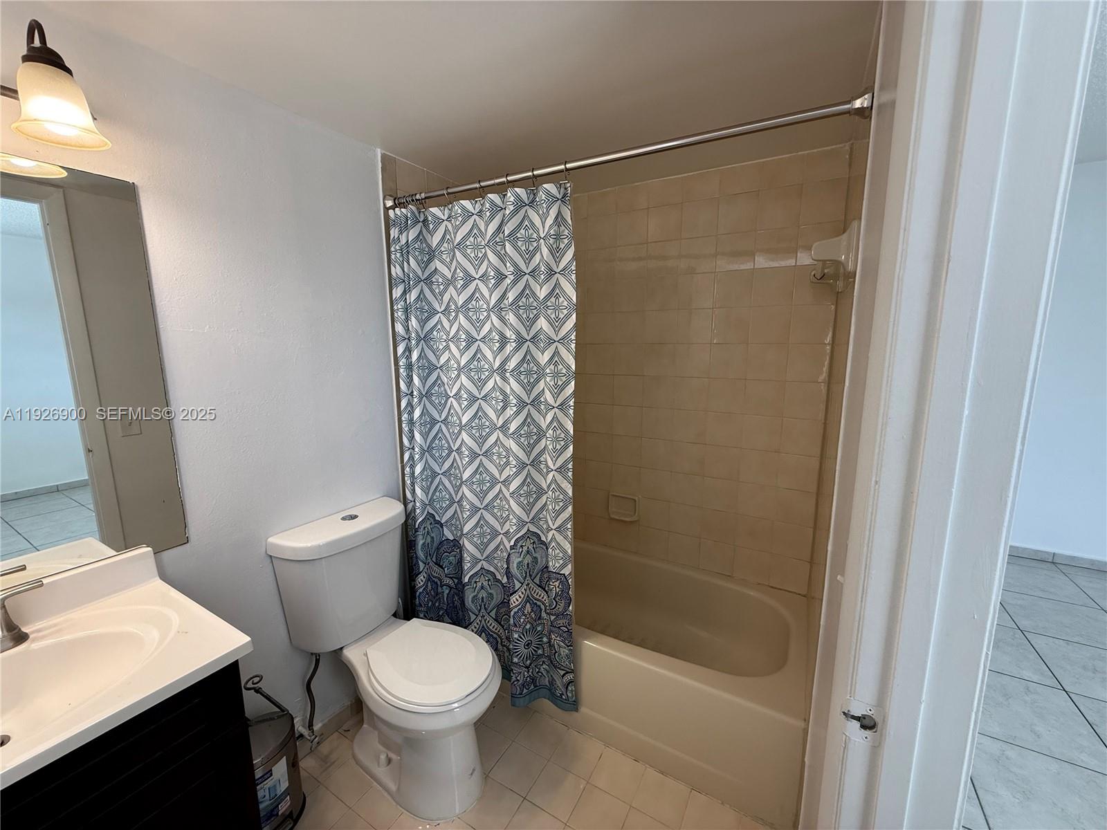 15969 Northwest 64th Avenue, Unit 504 Miami Lakes, FL 33014 - Photo 13 of 21 a white toilet sitting next to a bath tub