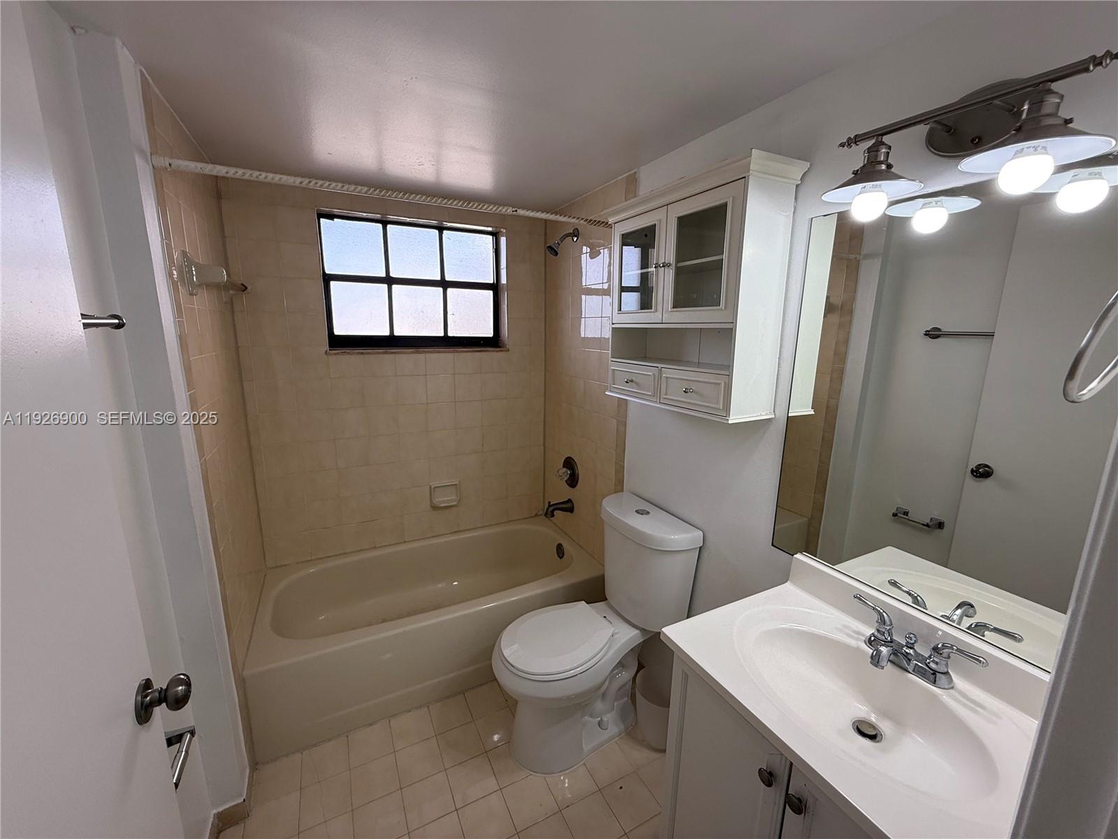 15969 Northwest 64th Avenue, Unit 504 Miami Lakes, FL 33014 - Photo 19 of 21 a bathroom with a sink toilet and shower
