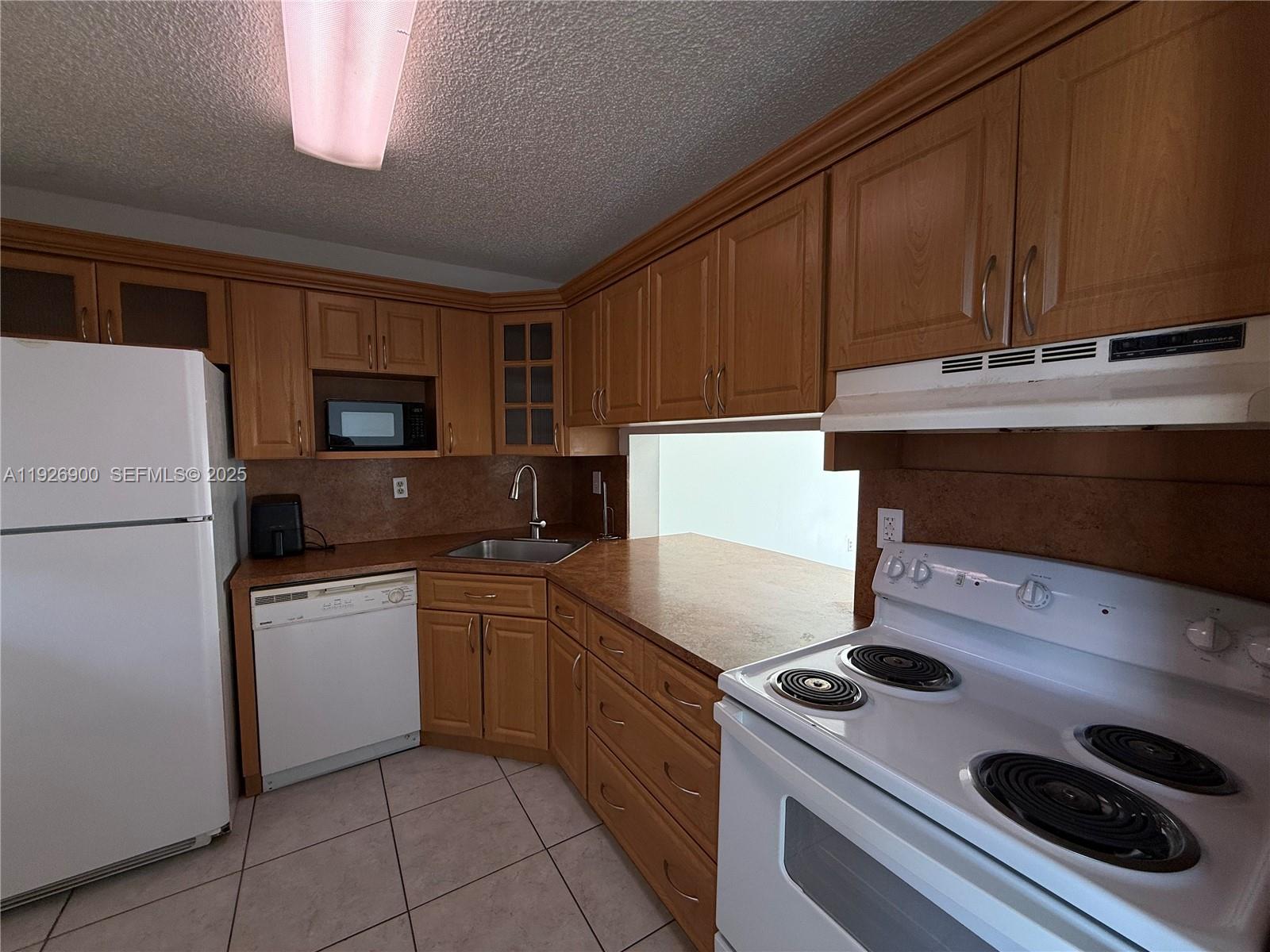 15969 Northwest 64th Avenue, Unit 504 Miami Lakes, FL 33014 - Photo 7 of 21 a kitchen with a stove and a refrigerator