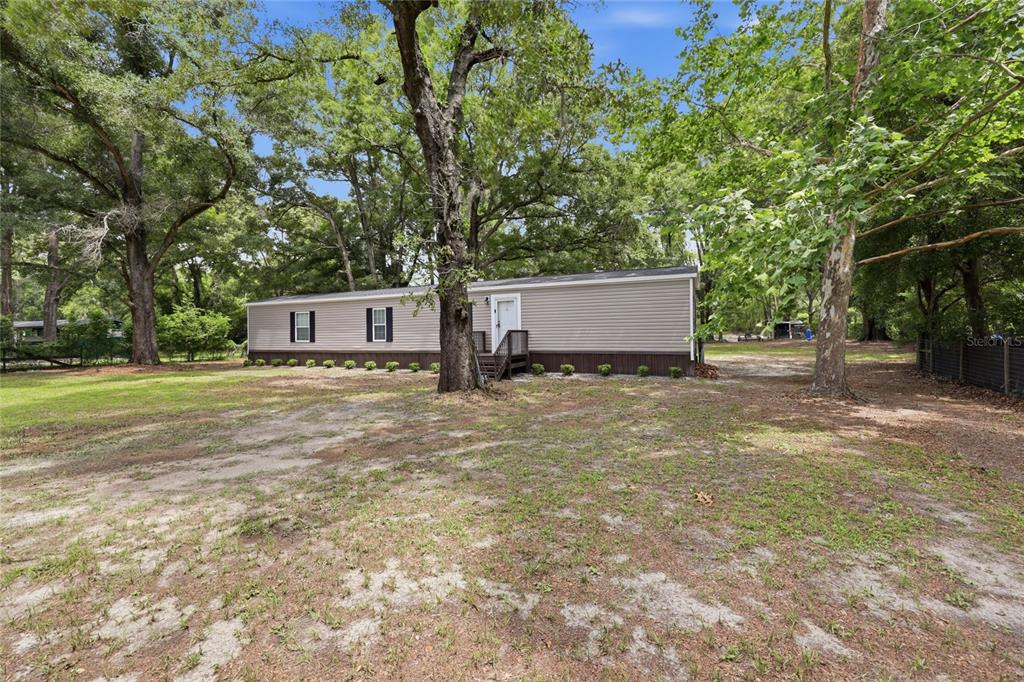 215 Southwest Alpine Place High Springs, FL 32643 - Photo 38 of 41 a white house that has a tree in front of it