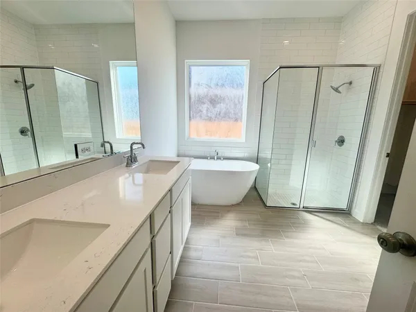 a spacious bathroom with a double vanity sink toilet mirror and bathtub