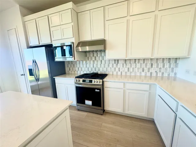 a kitchen with stainless steel appliances a stove a sink and a refrigerator