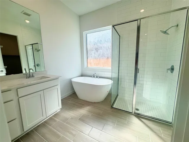 a spacious bathroom with a double vanity sink mirror and shower