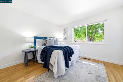 a bed sitting in a bedroom next to a window